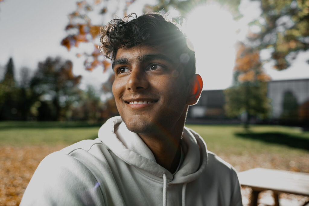 Kashif Chopra pictured sitting at a picnic table on the Quad.