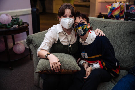 Two students pose for a picture, wearing masks.