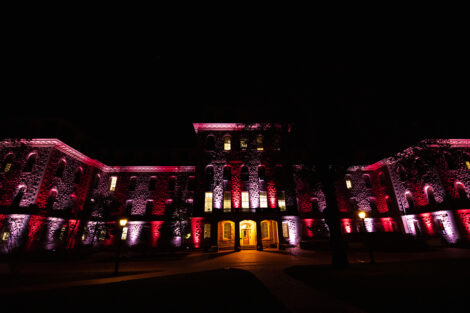 Pardee Hall, illuminated by maroon and white lights.