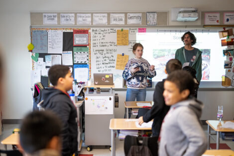 Two students teach in a classroom.