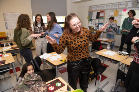 Lafayette students pretend to flap wings in the classroom of students.