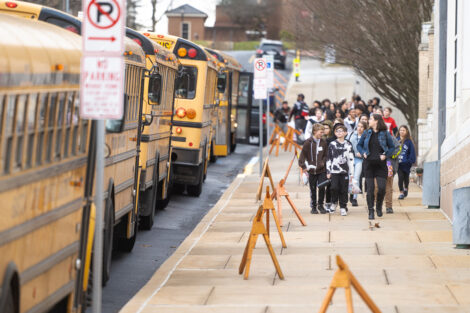 Students exit yellow buses.