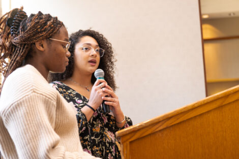 Two students speak at a podium.