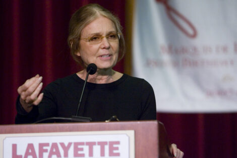 Gloria Steinem speaks at a podium.