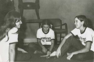 Three students sit on the floor