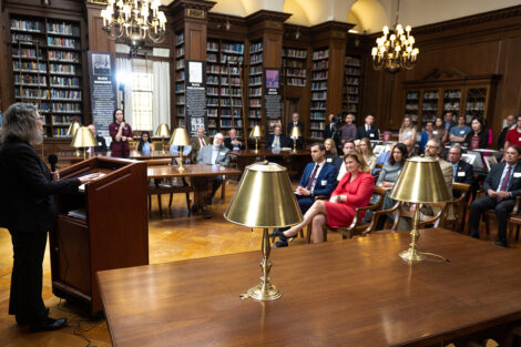 Wide angle shot of Margo Schlanger at the podium speaking to the audience.