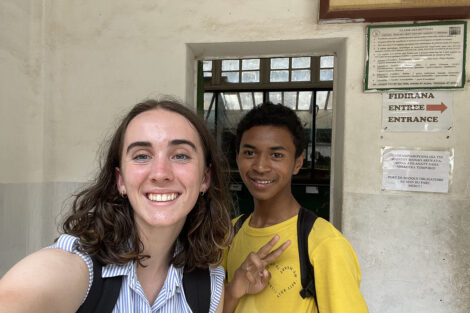 A student smiles with a Malagasy student