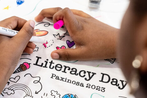 A student colors a Literacy Day page.