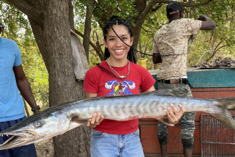 Eline Pellicano ’24 smiles, holding a large fish.