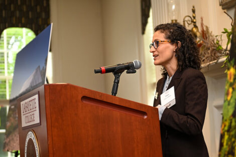 Delicia Nahman, director of sustainability, speaks at a podium at the luncheon.