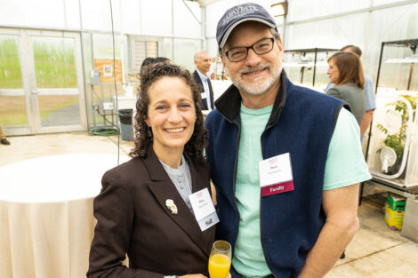 Delicia Nahman, director of sustainability and David Brandes, professor and chair, integrative engineering are standing arm in arm at the greenhouse.