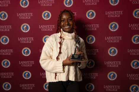 Jada Peters '24 smiles, holding an award.