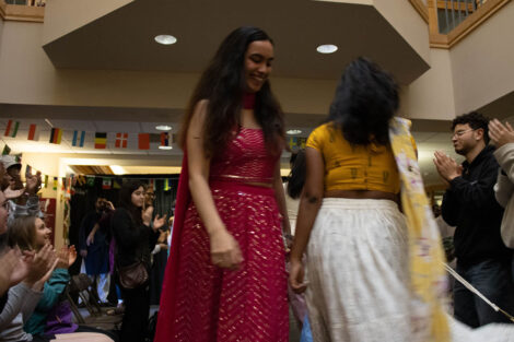 A student smiles walking on the catwalk.