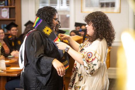 Karina Fuentes gives a student their multicultural stole.