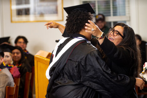 A staff member smiles as they embrace a student.