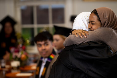 Two students embrace in a happy hug.