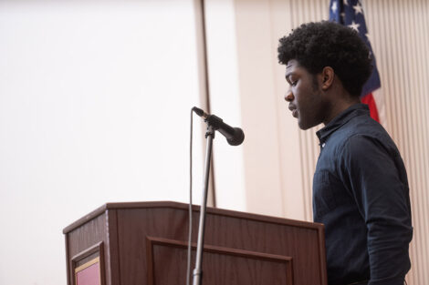 A student speaks at a microphone in Colton Chapel.