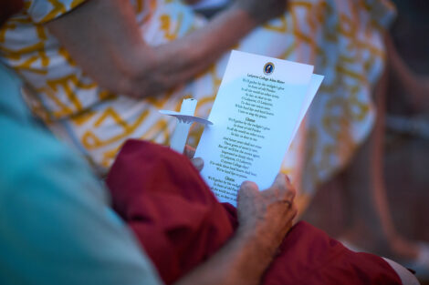 Picture of the lyrics to the alma mater held by an alum at Reunion.