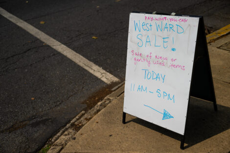 An A-frame sign reads West Ward Sale today with the times and details of the sale