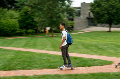 A student on their skateboard across the Quad.