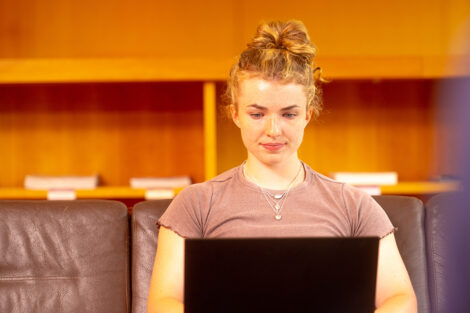 A student works on their laptop in Skillman Library.