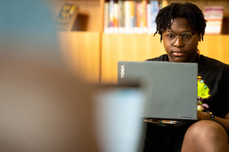 A student works on their laptop in Skillman Library.