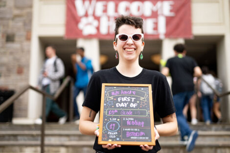 A student holds up a sign for their first day of school.
