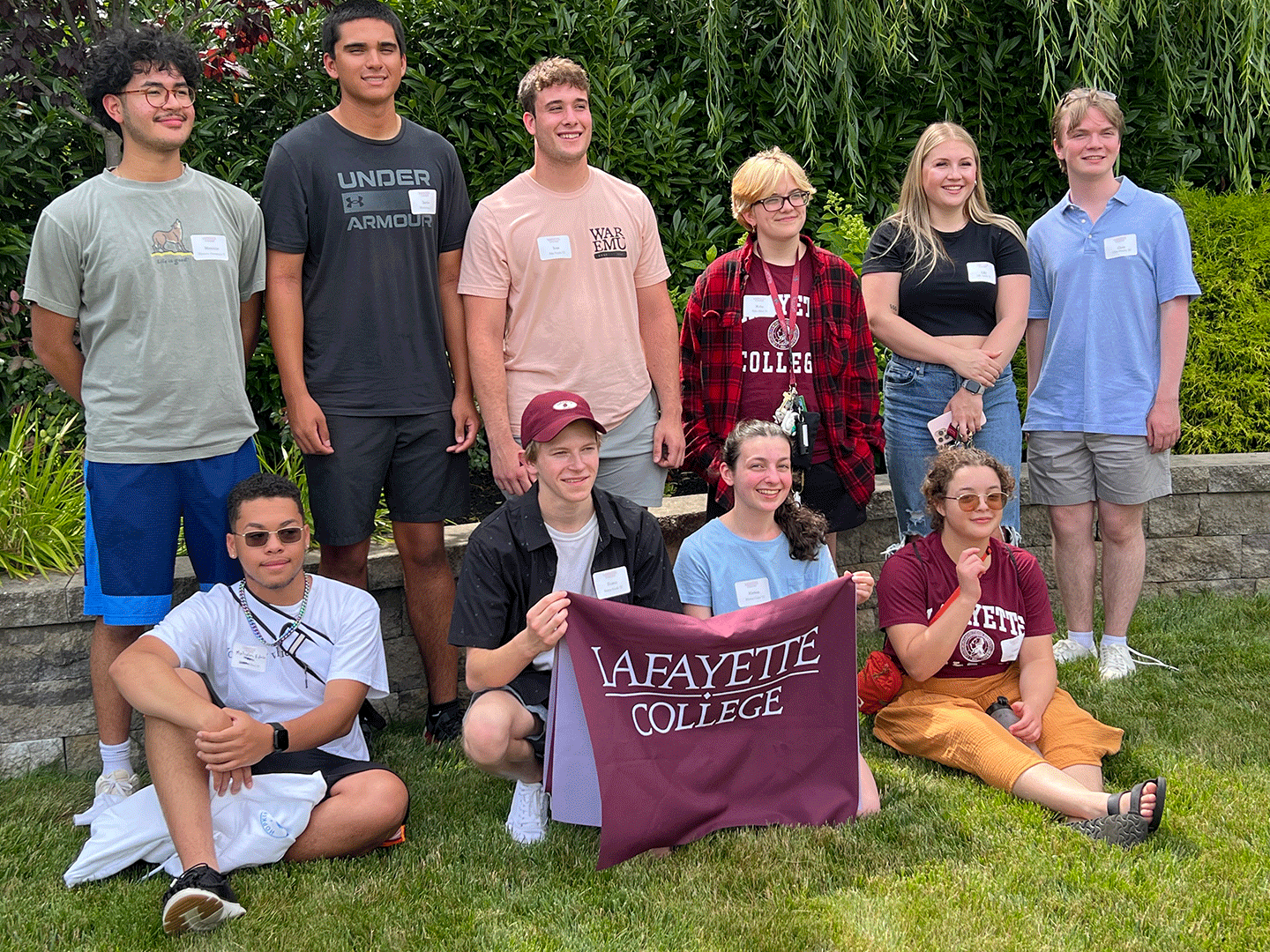 Incoming students smile at the camera and hold a Lafayette flag