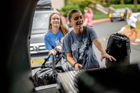 A student unpacks a car.