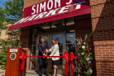 President Hurd cuts a ribbon in front of Simon's Market. She is with Rich Liebscher, chief information officer of Eat’n Park Hospitality Group