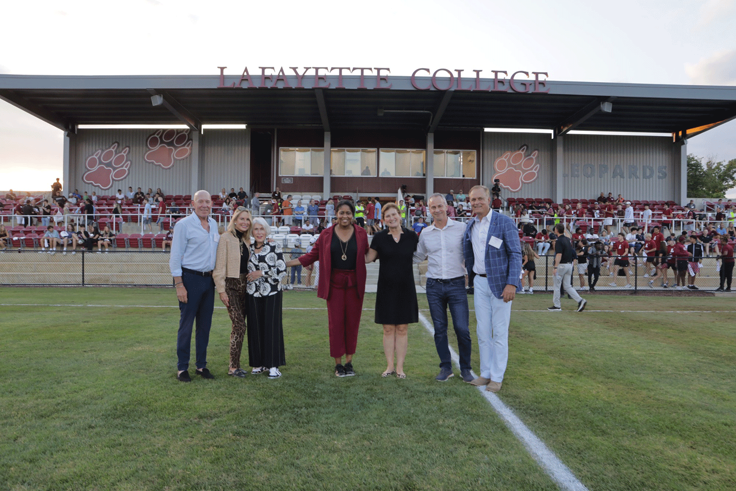 Standing on the field at Gummeson Grounds are from left: From left: Jud Linville '79, Cindy Oaks Linville '80, and Mary Ann Oaks joined Athletics Director Sherryta Freeman, President Nicole Hurd, Jim Benjamin '84, and Peter Gummeson '80