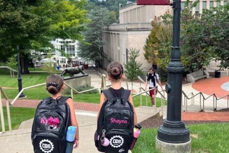 Two elementary-aged students walk through campus on their way to a clinic with the Lafayette Dance Team.