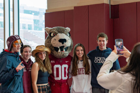 Families pose with the leopard mascot at Family Weekend