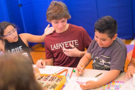 Lafayette students interact with younger students, doing craft activities.