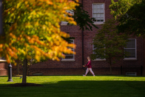 A student walks on a campus path.