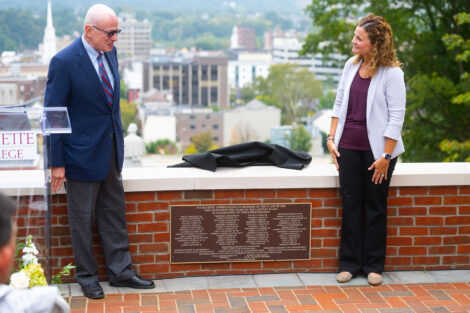 Jeffrey Ruthizer ’62 P’00 and Audra Kahr executive vice president Finance & Administration unveil a plaque at the dedication. They are looking at the plaque that is on a brick wall.