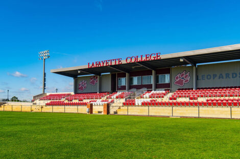 Gummeson Grounds stadium is shown. Maroon and white seats are framed by a roof with the words Lafayette college.