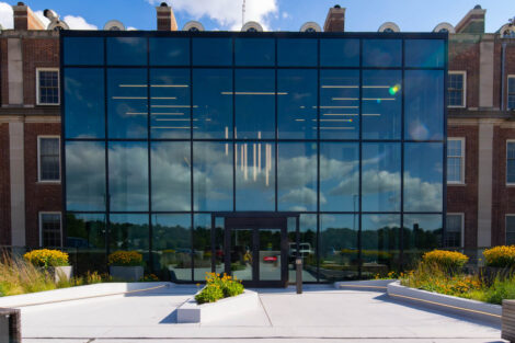The glass-fronted exterior of the Hugel Welcome Center is shown.
