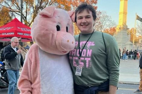A Lafayette student stands near the PABF pig during PA Bacon Fest 2023.