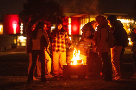 Students gather around the fire pit.
