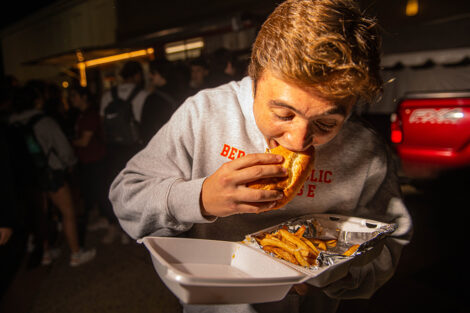 A student eats food from the food truck.