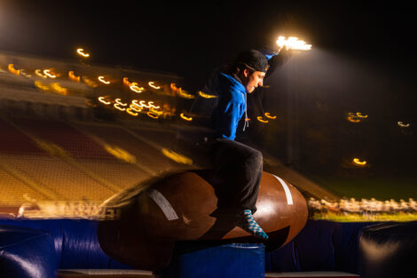 A student rides a mechanical football