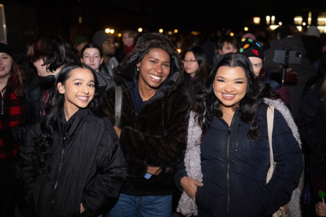 Students smile, bundled in warm clothing.
