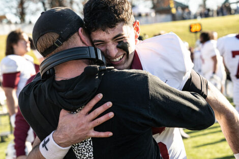A football player hugs a coach.