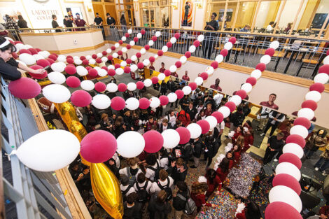 Balloons and confetti cover a crowd in Farinon College Center.