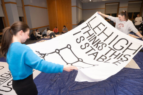 Students hold sheet which reads 