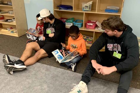 Two Lafayette student athletes read with two young students at Third Street Alliance.
