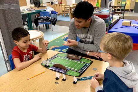 A Lafayette student athlete plays a game with two children at Third Street Alliance.