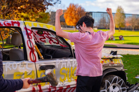 A student celebrates next to the Lehigh car.