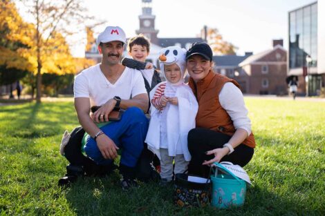 A family poses on the Quad in costume and with trick-or-treat buckets for the College's trick-or-treat event.